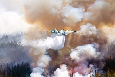 CL-215T flying over wildfire